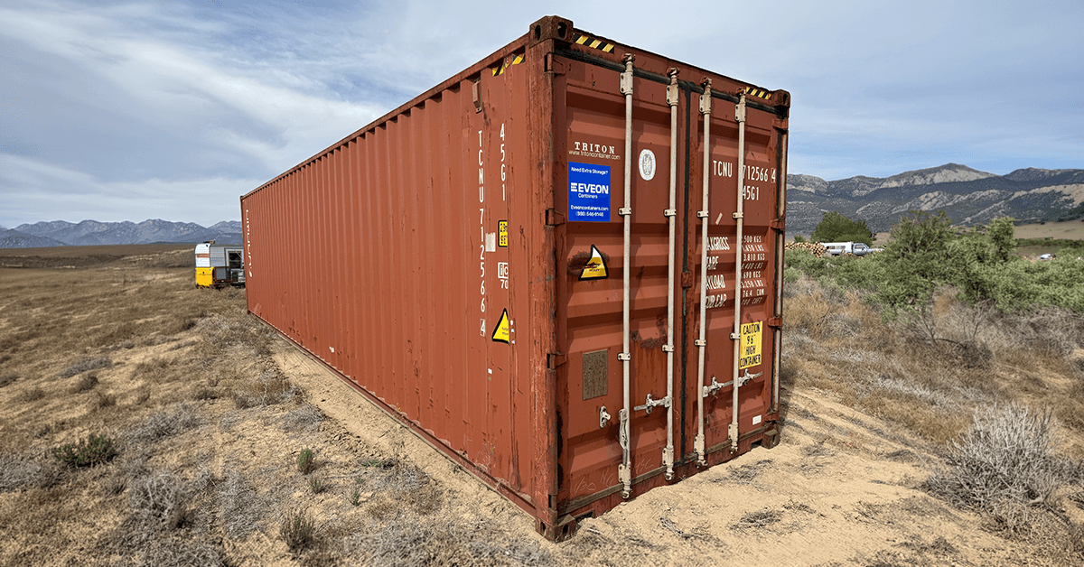 Red 40ft HC container in a field
