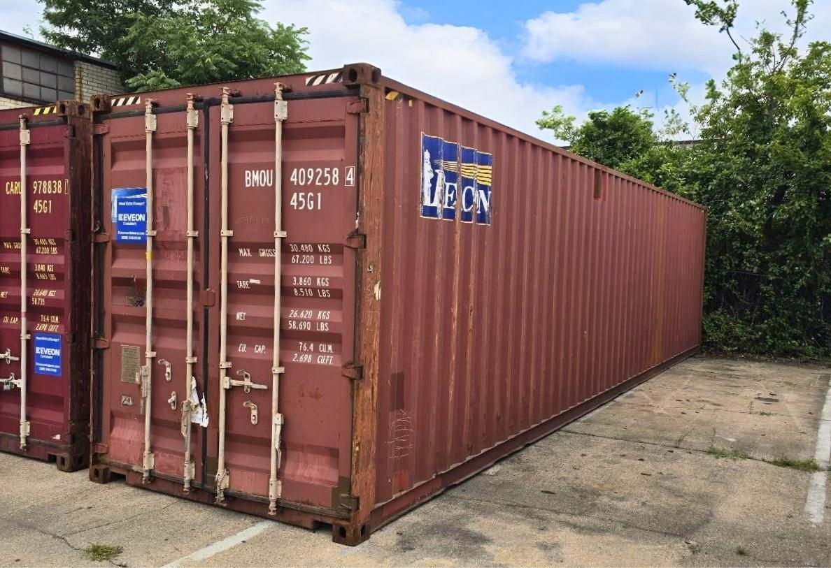 Red used shipping container on concrete