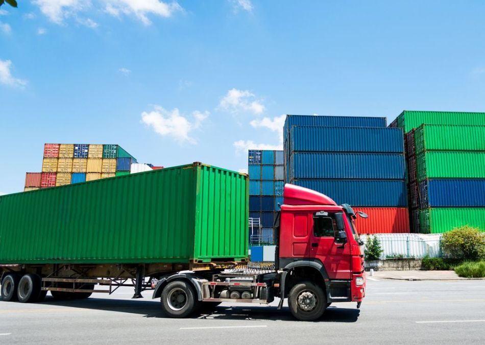 Truck picking up a green container at depot