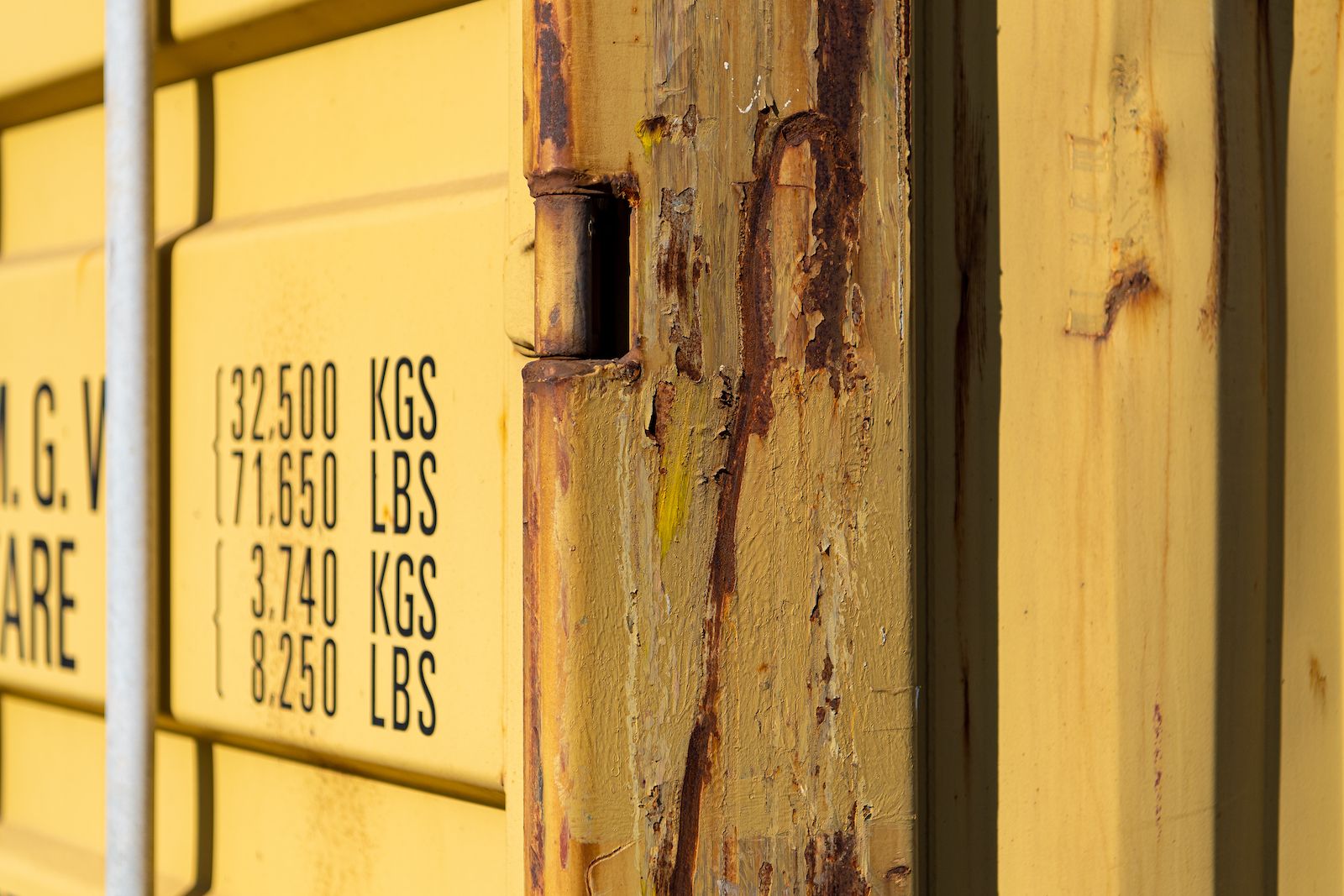 Close up of a yellow container door hinge