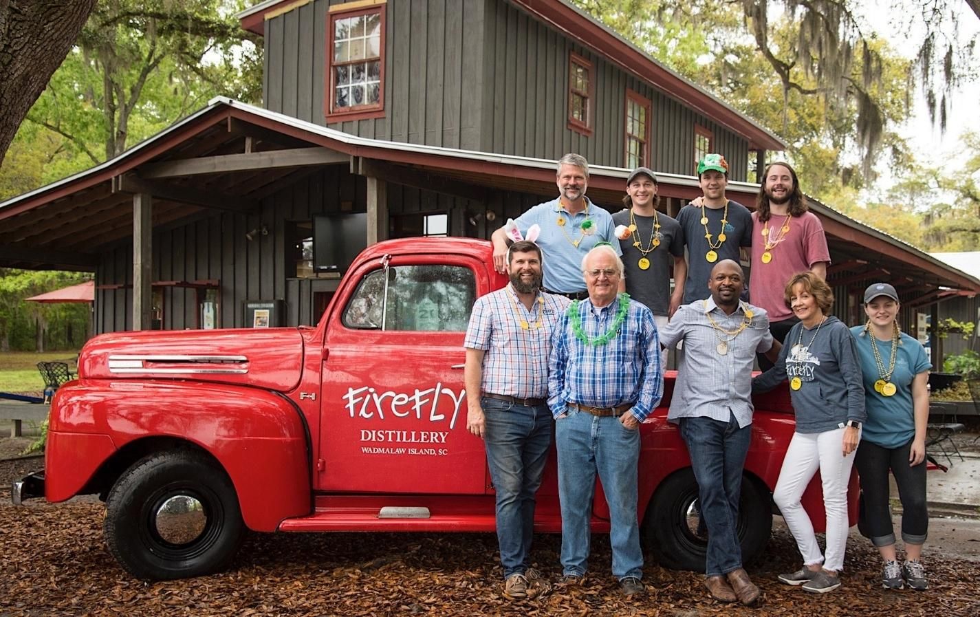 Original members of Firefly standing next to red, branded truck