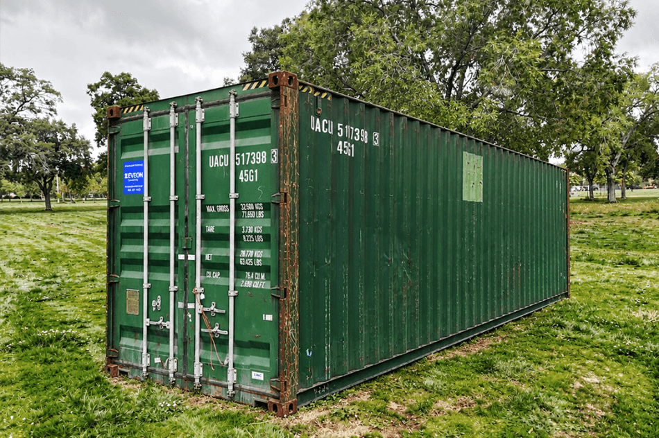 Green shipping container in a field