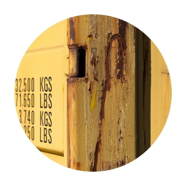 Side of yellow container with rust