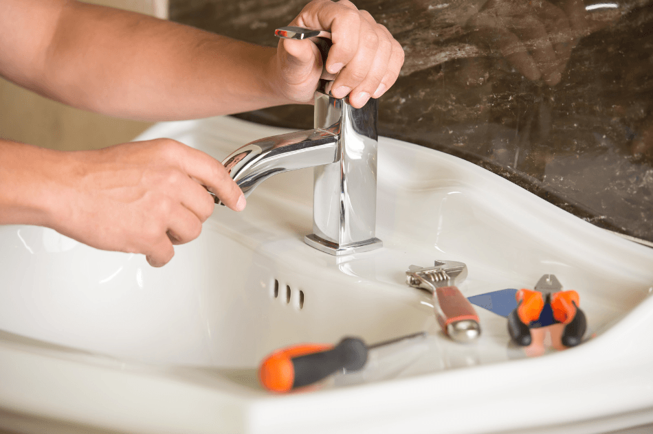 person fixing sink and plumbing