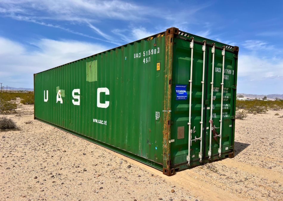 Green shipping container on gravel